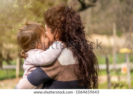 Little baby girl kissing and hugging her mom 