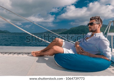 happy holiday Luxury Travel by Catamaran in the Ocean by the Seychelles island, Young man at sailing boat