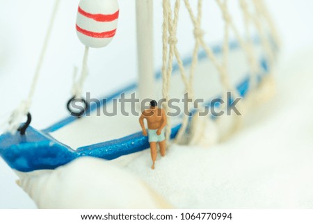 Miniature people: Sandy beach with tourists using as background traveling, exploring the world, business concept.