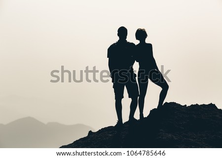 Couple celebrating, reaching life goal and love, business concept with man and woman looking at view. Motivational and inspirational silhouette landscape.