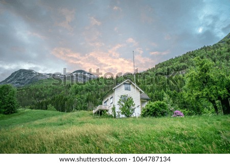 The house on the hill , with special clouds above . Photo taken near the town of Stryn in Norway . 