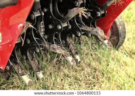 Close up of a mechanical lawn aerator. Royalty-Free Stock Photo #1064800115