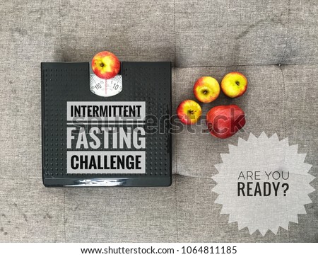 Conceptual image of intermittent fasting challenge with apples and weight scale as symbolic of weight loss