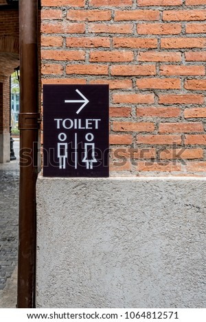 Toilet modern sign label on concrete brick wall