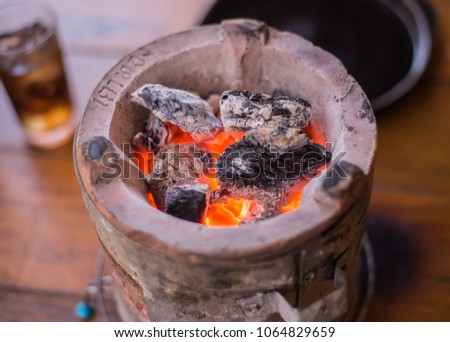 charcoal burning in Asian stove on the table   and soda