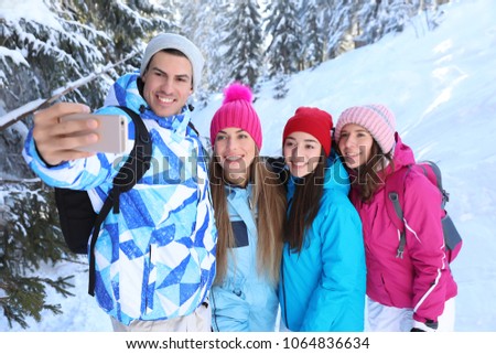 Group of friends taking selfie at snowy resort. Winter vacation