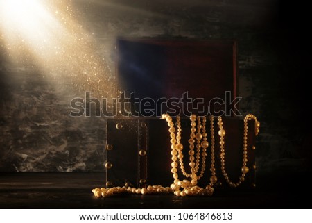 Image of mysterious opened old wooden treasure chest with light. An adventure and fantasy medieval period. Selective focus