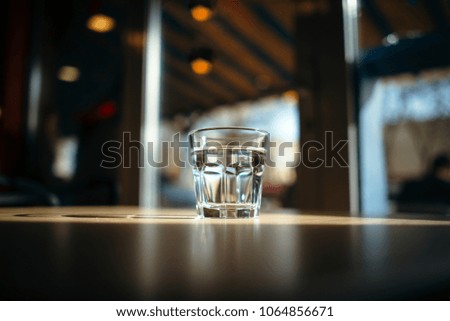Glass of water on wooden table bokeh background