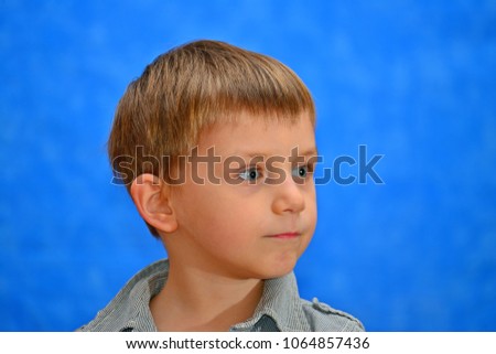 Boy in the studio with a gift on a blue background