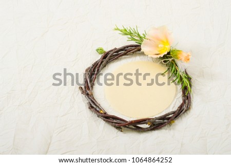 wedding wreath with mallow flower and rosemary twigs on creased beige textile background