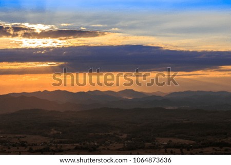 The sun sets in the mountains in Thailand