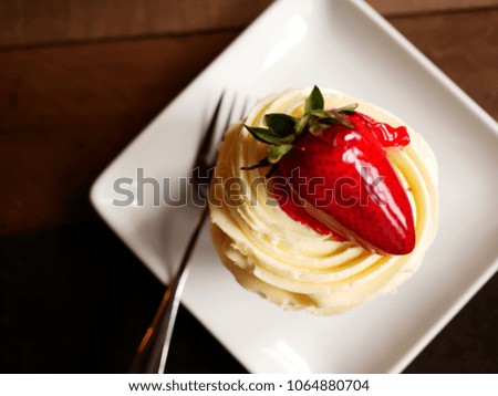 Top view image of chocolate strawberry cupcake on a wooden table background / Selective focus