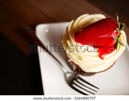 Top view image of chocolate strawberry cupcake on a wooden table background / Selective focus