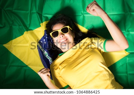 Beautiful girl with flag cheering. Woman celebrates sports over white background. Painted faces and cheering
