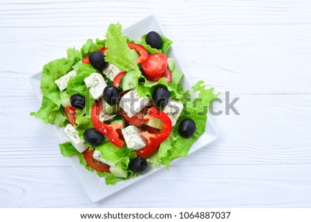 Greek salad on a wooden background. Space for text or design.