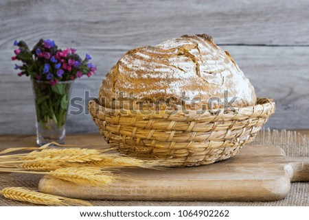 A loaf of sourdough bread in a basket on a table