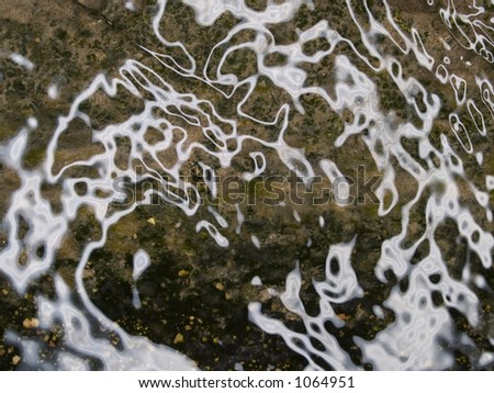 Stock macro photo of water ripples over a gritty background.  Useful as a layer mask.