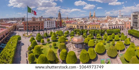 panoramic aerial view of the Main square in the center of Leon Guanajuato with a copper kiosk in the center, in the background the city and the Parroquia del Sagrario Royalty-Free Stock Photo #1064973749