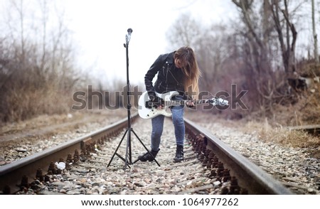 Beautiful young girl rocker with electric guitar. A rock musicia