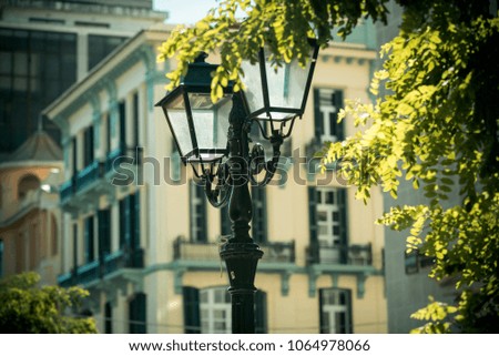 Vintage style old street lamp in park, defocused. Beautiful retro street lamp old fashioned architecture, building on background. street lighting concept. Old city, ancient architecture, park.