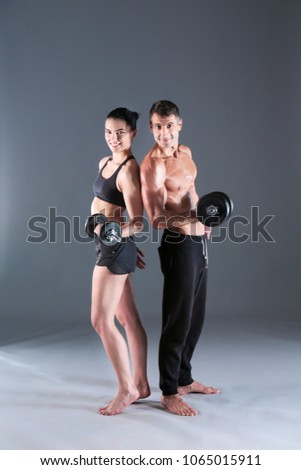 Athletic man and woman with a dumbells. Personal fitness instructor. Personal training.