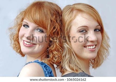 Pretty young red-haired laughing sisters. Happily laughing sisters
