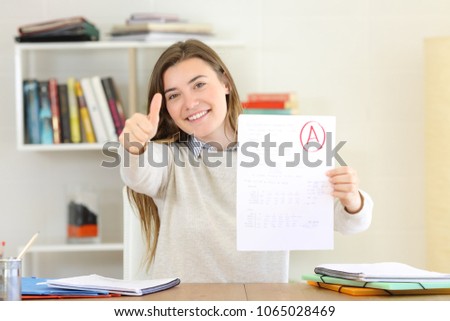 Proud student showing approved exam to camera at home Royalty-Free Stock Photo #1065028469