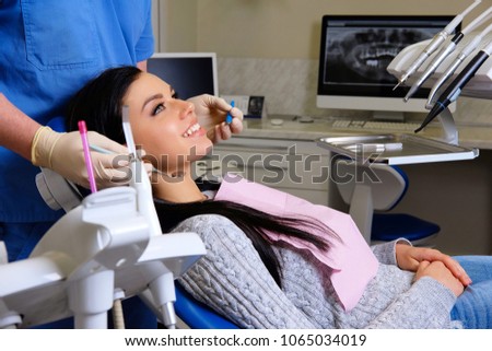 Beauty brunette having teeth examined at dentists.