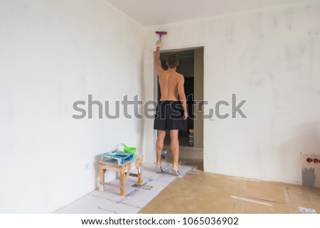 The man is doing apartment repair cleaning the walls before painting at new house
