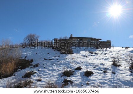 A home on a peak in the Bountiful Utah hills, with the sun shining in the blue sky
