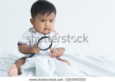Cute asian boy play magnifying glass