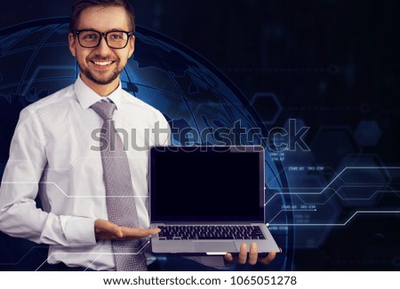 Cropped image of young male businessman holding in his hands laptop with blank black screen. Futuristic virtual  background. Mock up, copy space for your text. Business, finance, innovations concept.