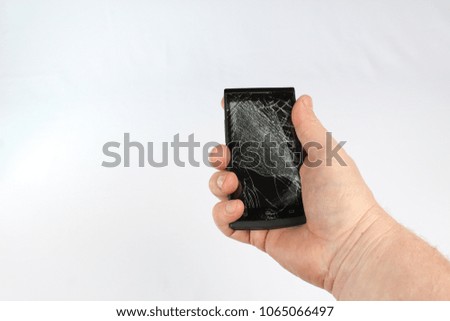 Smartphone with a broken screen in right hand