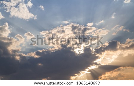 Sunset with dramatic sky with sun rays. Contrast between warm and cold colors