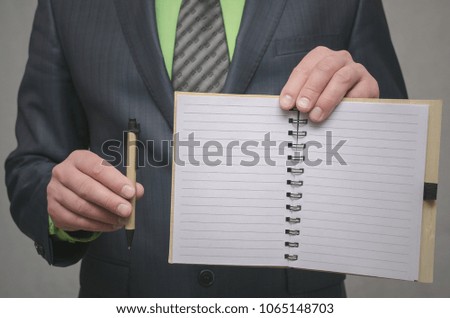 Businessman holds in hand a note pad with pen. To do list template. Goals or business tricks. Business tips concept. Task Manager
concept. Special offer.
