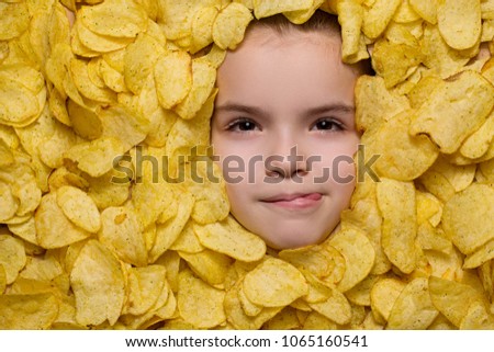the child lies with the chips, the girl on the diet does not eat harmful foods. Shooting from the top view of the camera