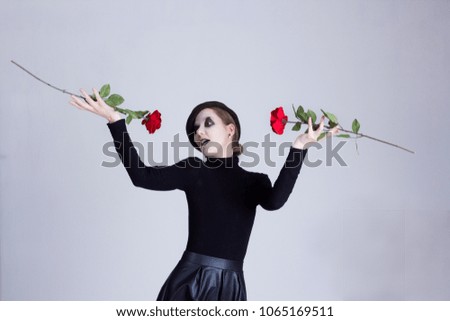 Mime girl with red roses on a gray background