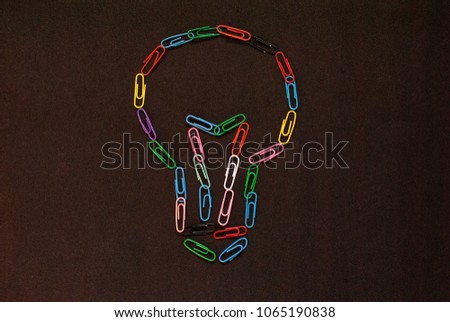 Colorful paper clip put on the black background as the bulb for idea concept.