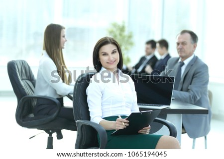 young business woman with clipboard on the background of business team
