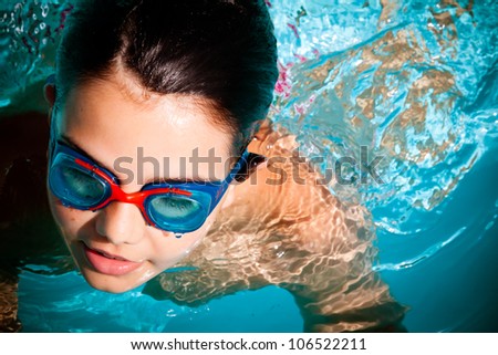 A kid swimming and having a good time in a pool. Sports concept. Royalty-Free Stock Photo #106522211