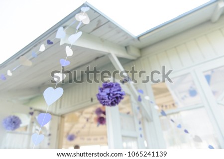 wedding, baby shower or birthday party purple decoration, flags,craft pom poms and paper balls on white ceiling