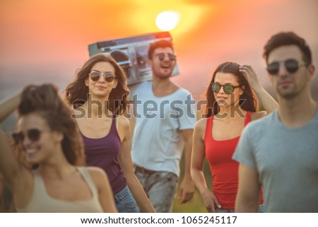The five friends stand on the sunrise background