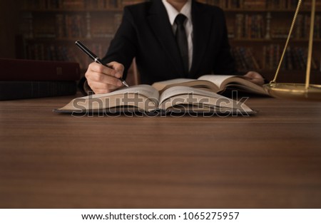 legislation, legal, law concept. business lawyer reading law books to advice client. with copy space. Royalty-Free Stock Photo #1065275957