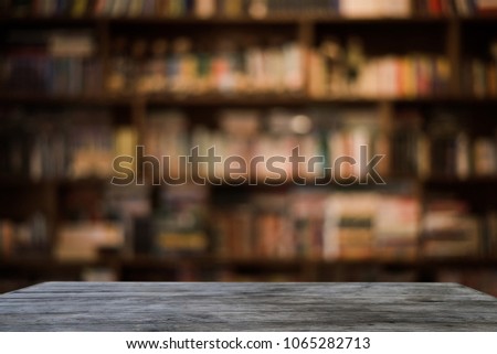 Empty space on wooden table in front of abstract At the library blurred background of light bokeh.