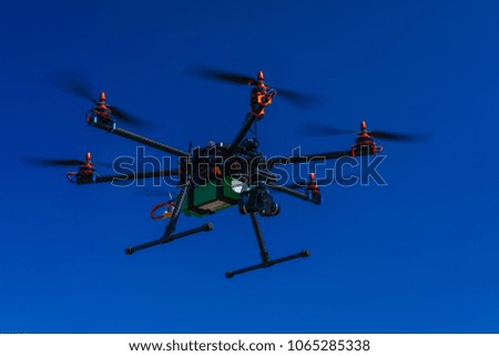 Drone quad copter flying with digital camera. Clear blue sky on the background. Active timespending at sunny day. 