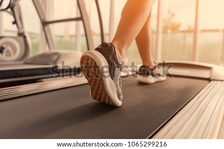 Exercise treadmill cardio running workout at fitness gym of woman taking weight loss with machine aerobic for slim and firm healthy in the morning.Show of running shoes, rubber floor, softness,  Royalty-Free Stock Photo #1065299216