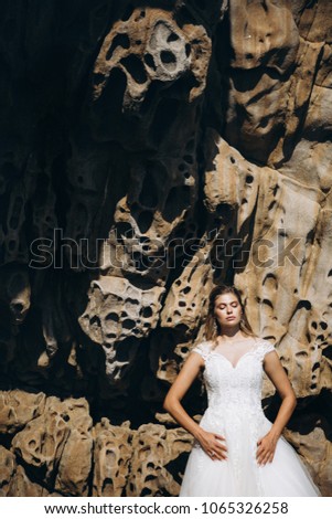 Beautiful blonde bride in handmade wedding dress during sea photoshoot