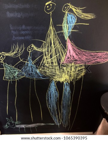 'Family' as depicted by a preschooler, chalk drawing art on black chalk wall. Mother, father, daughters, sisters