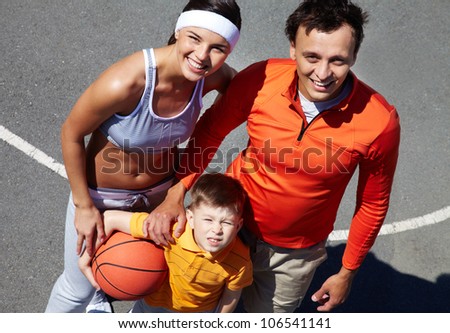 The above-view portrait of a family basketball team looking up with smile