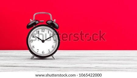 alarm clock on a color background on a wooden board